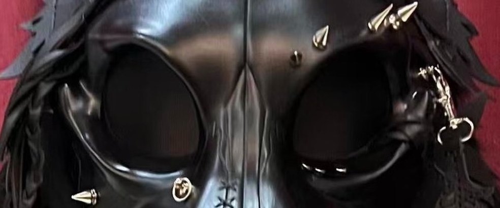 Close on CURFEW: a black bone mask with silver spikes
