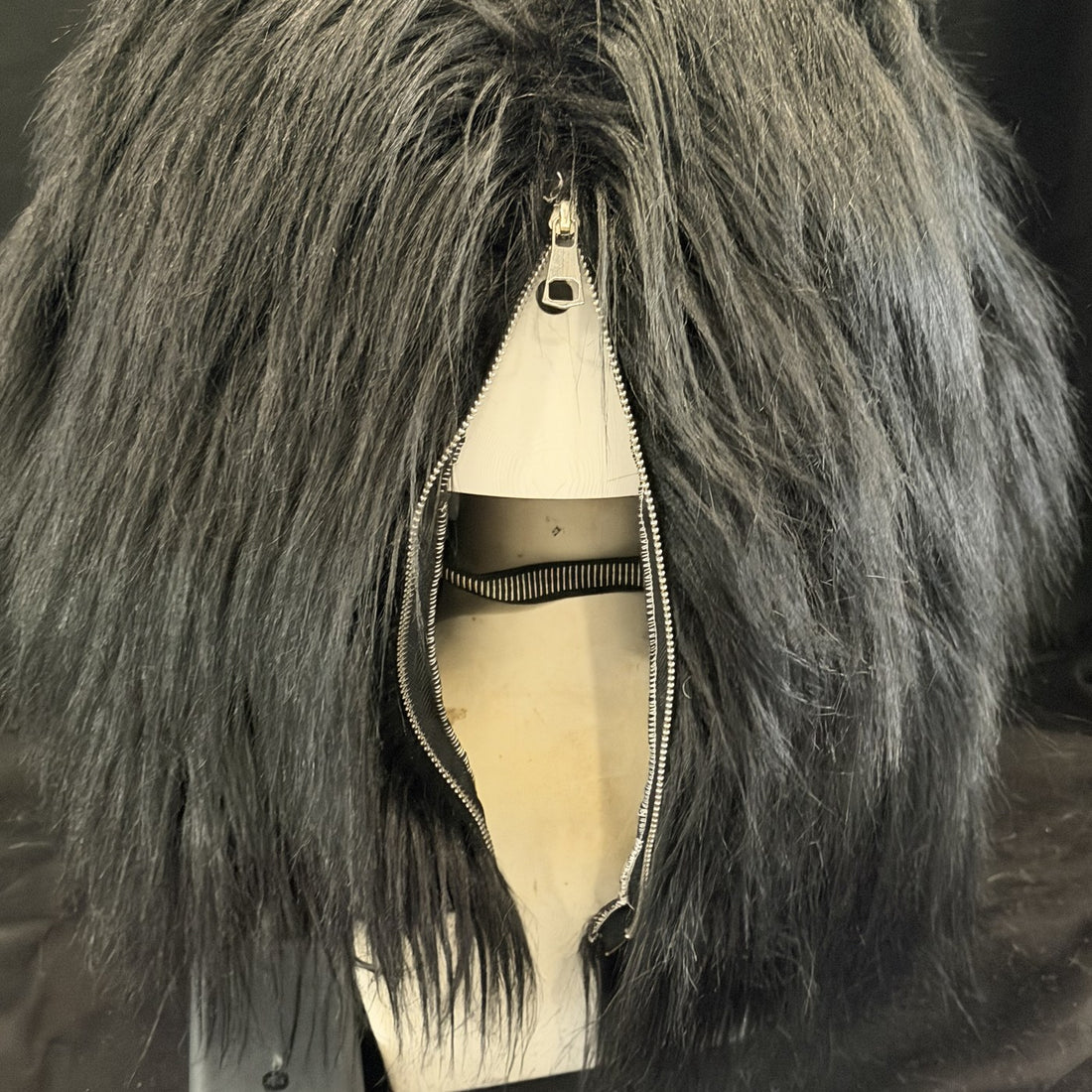 The zipper runs down the back, under the mane